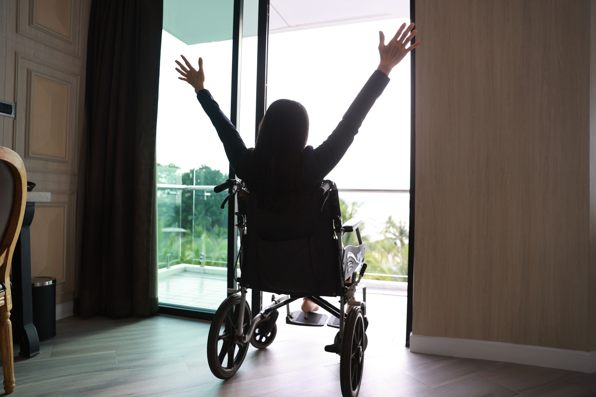 Handicapped person or patient sit on wheelchair  raising a hand up express happiness and freedom