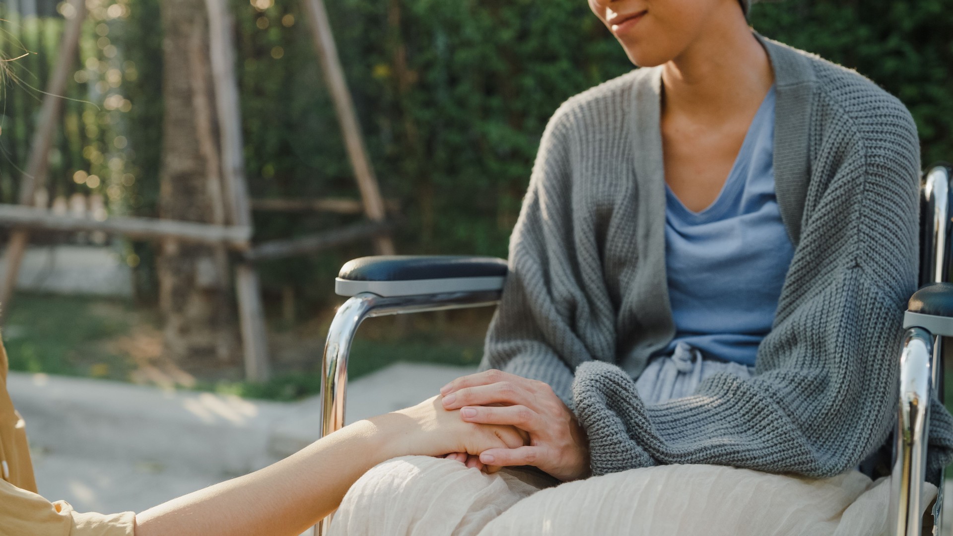 Closeup of young Asian people holding hands trust comfort help cancer patients talk crying stress relief outside home. Healthcare.